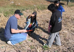 Steve collecting soil from a rice paddy with La-orsri's graduate students